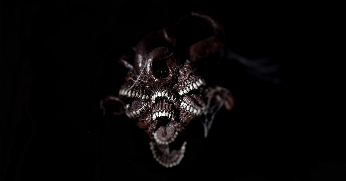 A promotional screenshot of artwork from the Eldritch Automata Backerkit campaign, showing a twisted monster made up of multiple mouths of teeth in a dark background.