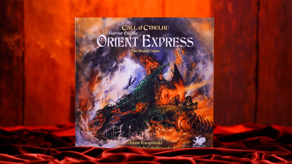 A promotional image of Horror On The Orient Express: The Board Game, showing the board game on a dark red velvet cover.