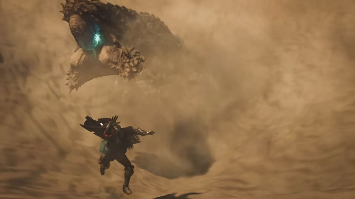 The hunter dodges a monster in a sand trap in Monster Hunter Wilds