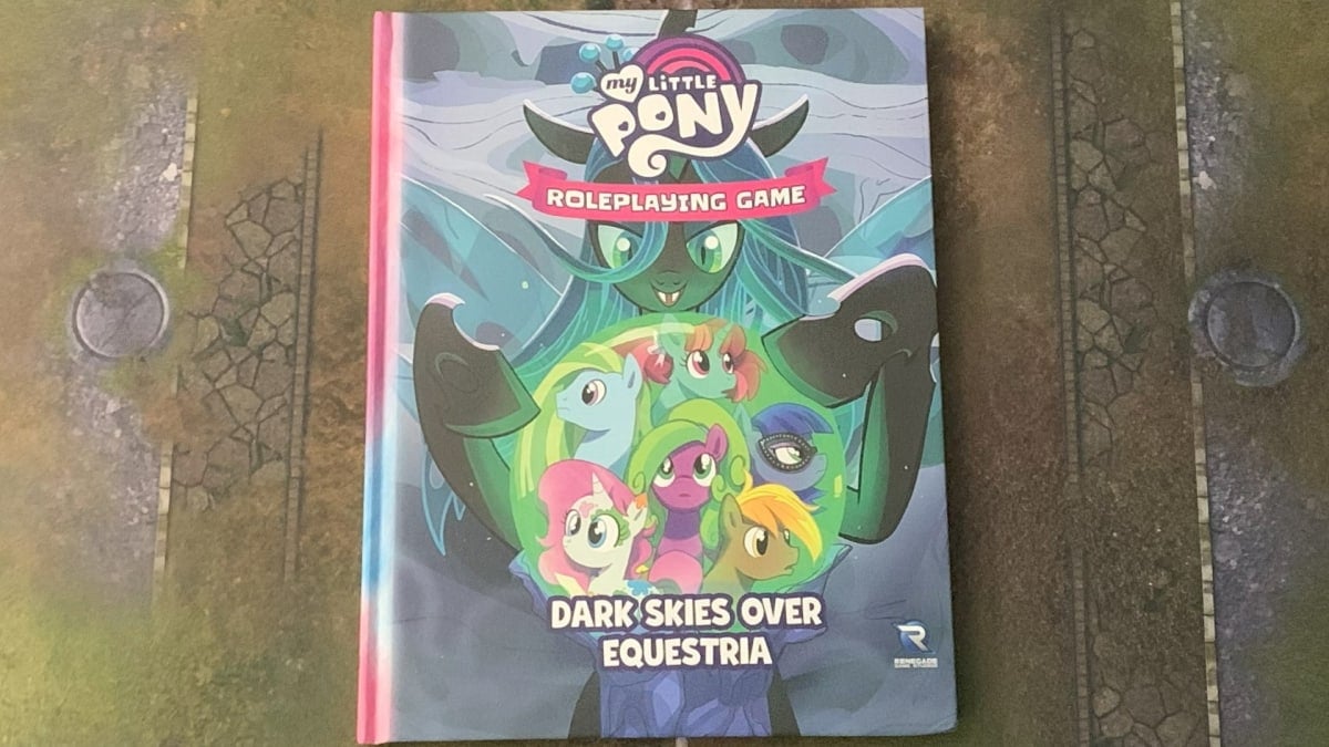 A photo of a copy of My Little Pony: Dark Skies Over Equestria on a gaming mat.