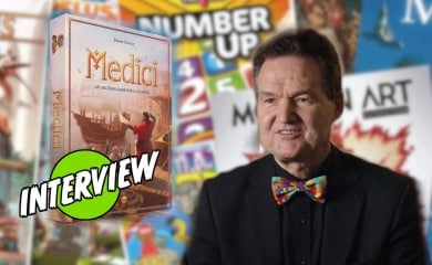 Reiner Knizia and the Medici box against a background of his other games